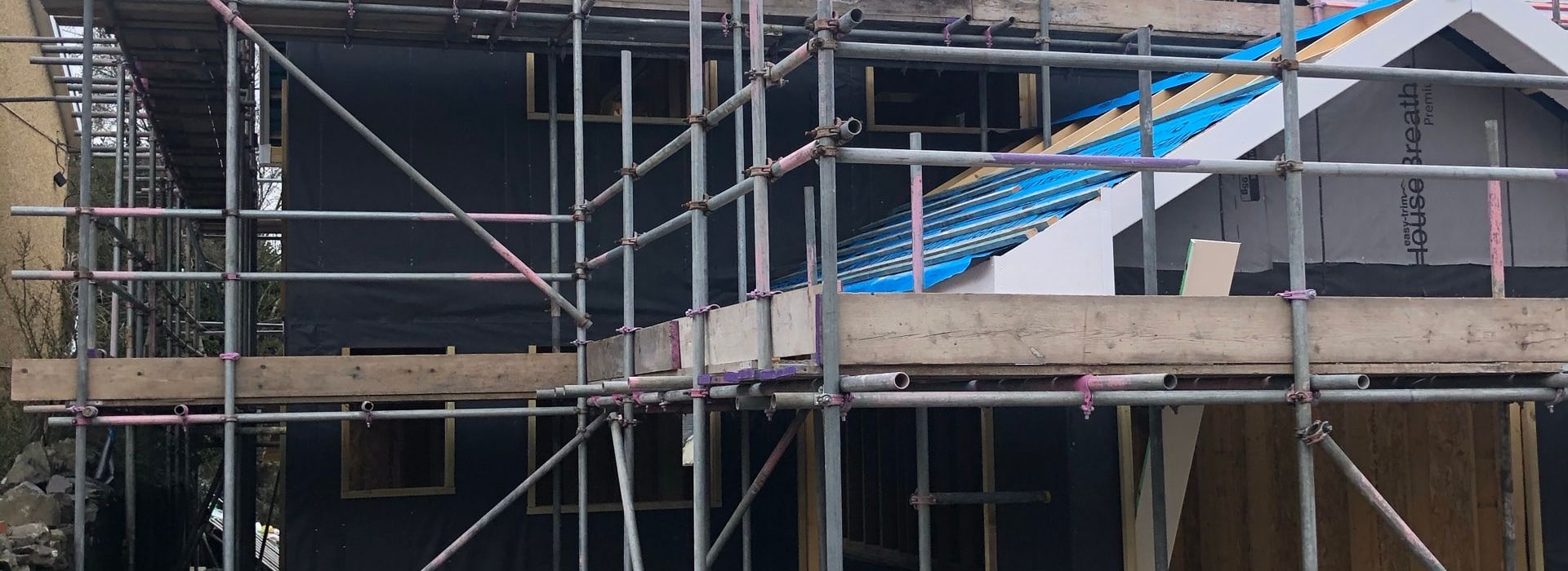 A timber-frame new-build home under scaffolding