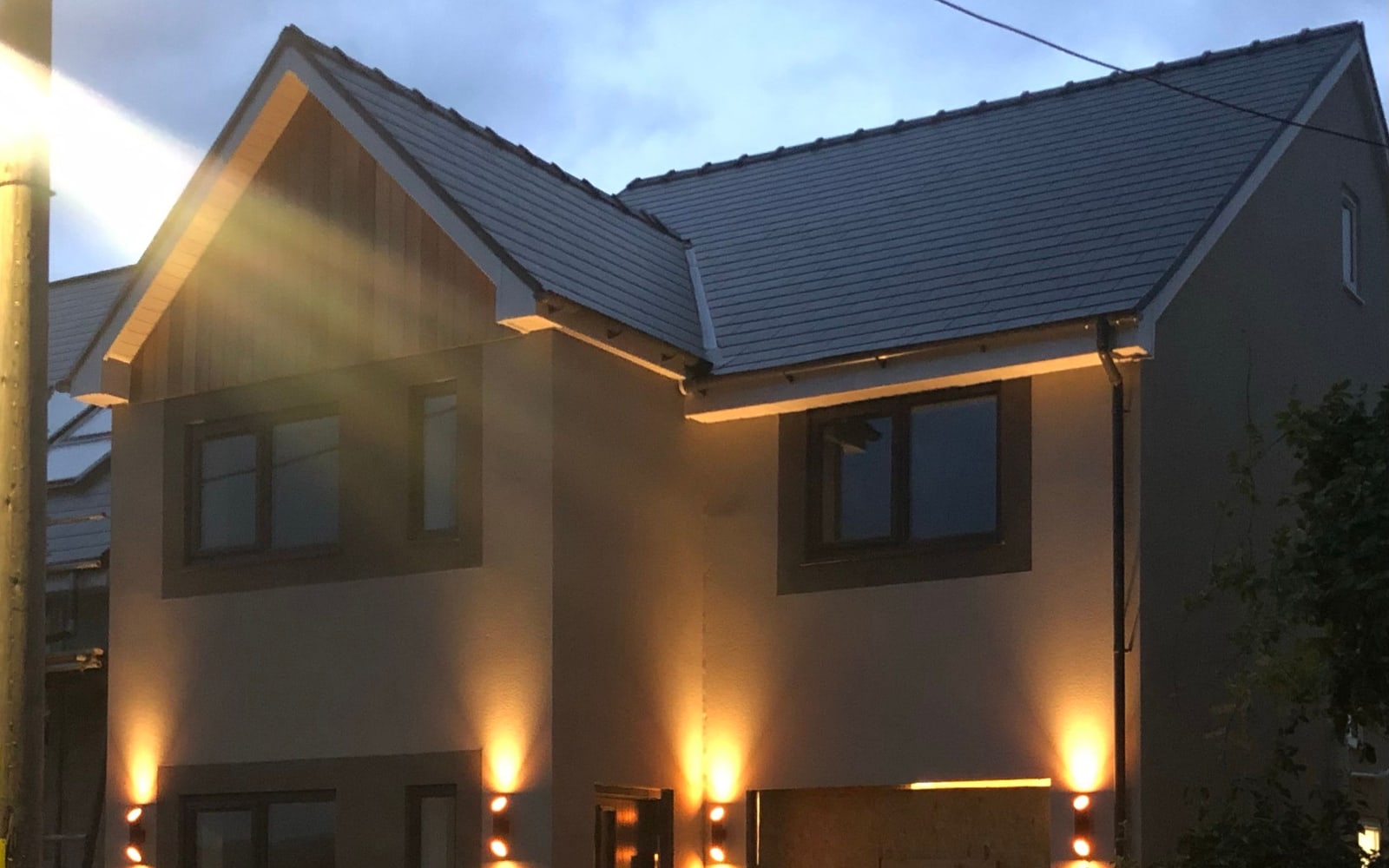 A finished detached new-build home at Heol Fawr, lit at dusk